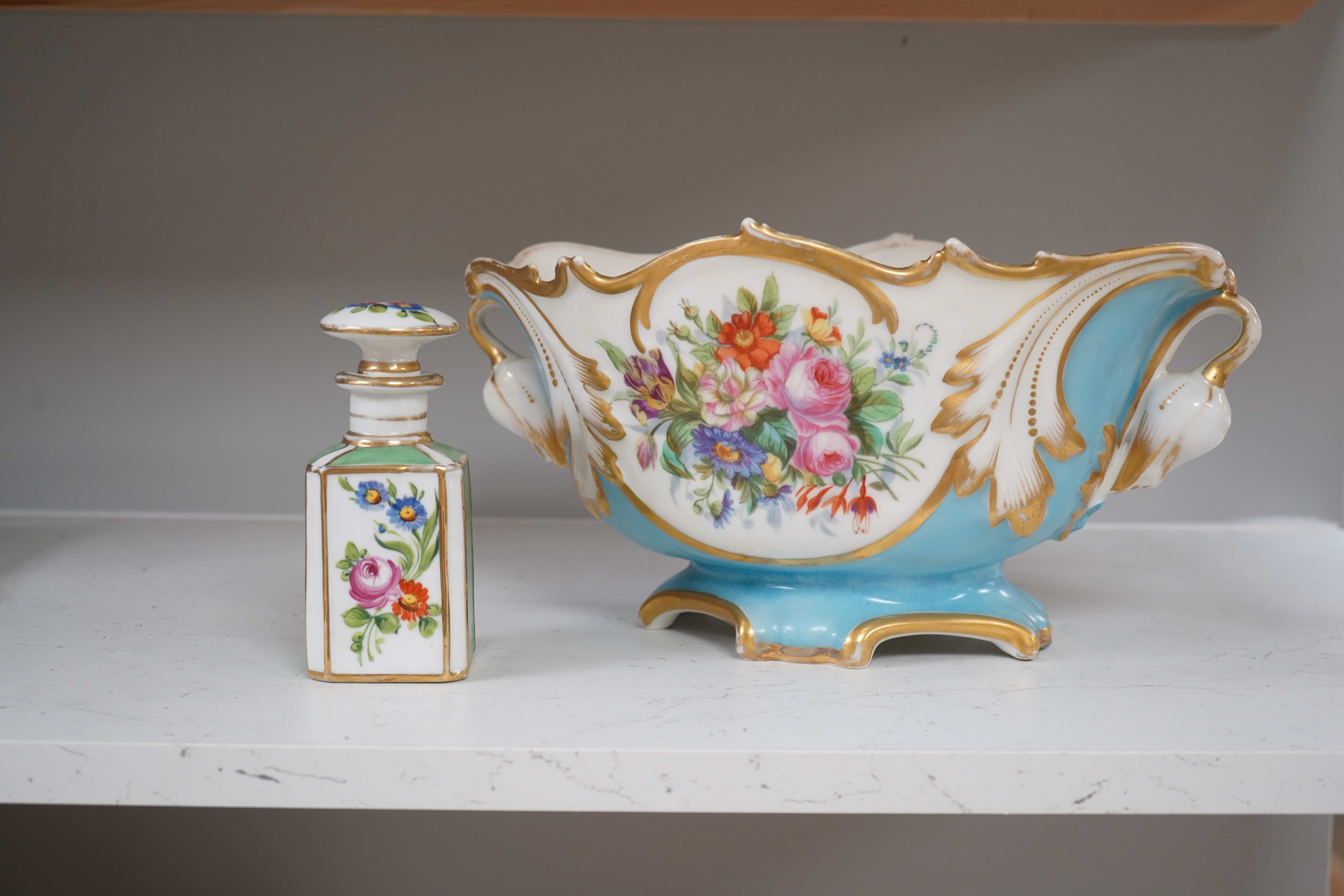A Sevres style flower painted navette shaped jardiniere and a similar French scent bottle and stopper, late 19th century, largest 38cm wide. Condition - fair to good